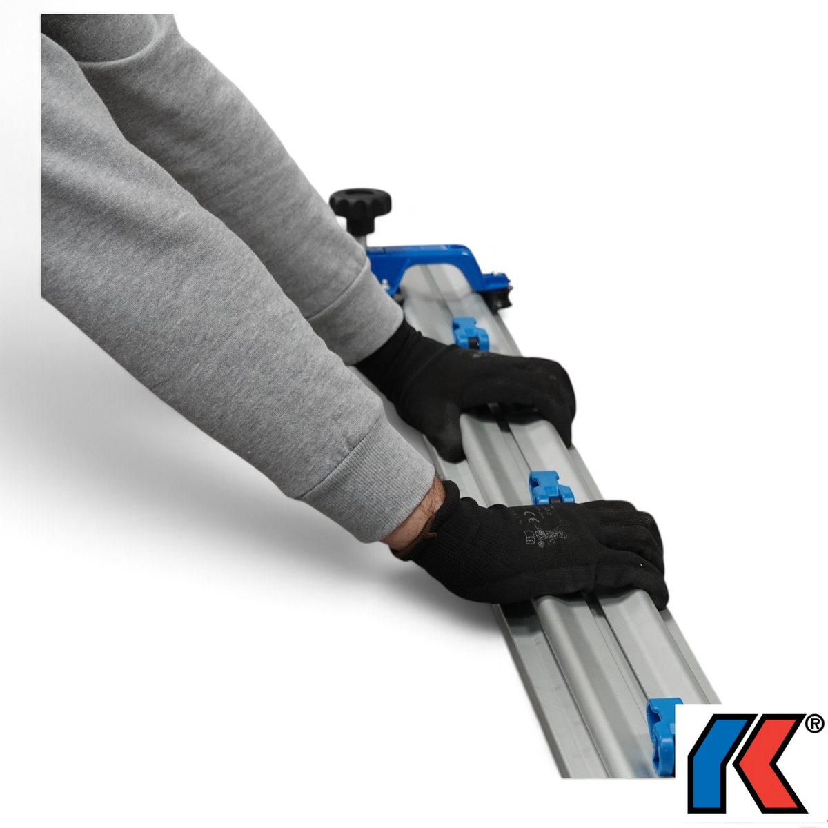 Werkfit Kaufmann Schienen-Schneidesystem beim präzisen Schneiden einer großen grauen Fliese mit Führungsschiene