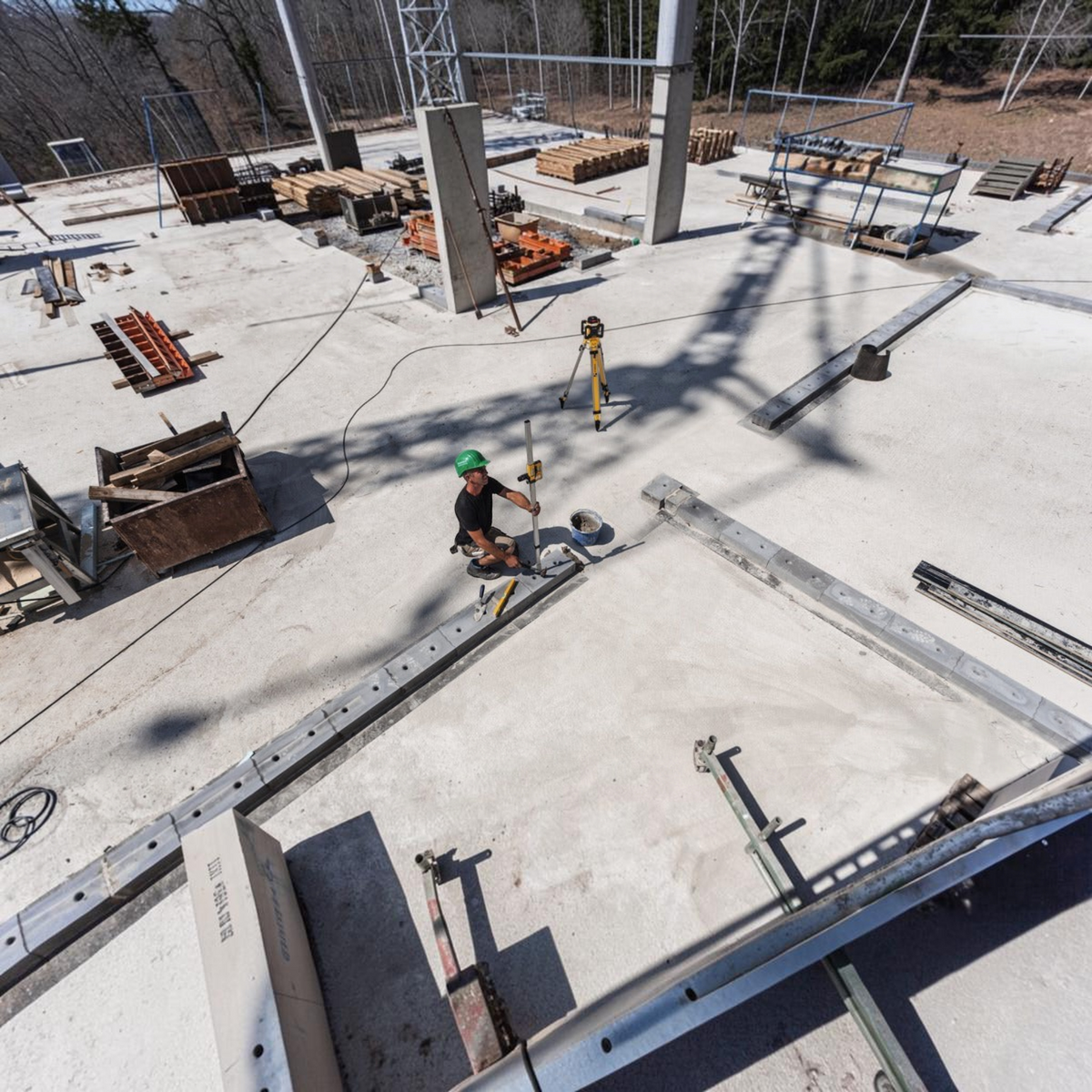 Werkfit Rotationslaser LAR 160 Set im Einsatz durch Bauarbeiter auf einer Baustelle mit Stativ und Messlatte