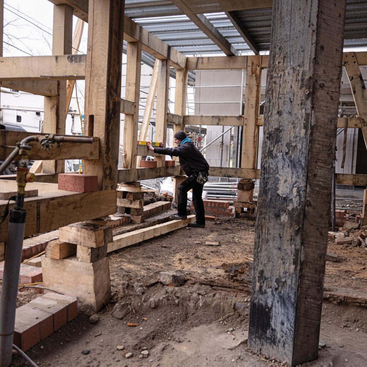 Handwerker nutzt Werkfit Elektronik-Wasserwaage TECH 196 DL an einem Holzrahmen auf einer Baustelle