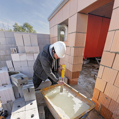Handwerker mit Werkfit Elektronik-Wasserwaage TECH 196 DL bei der Arbeit auf einer Baustelle