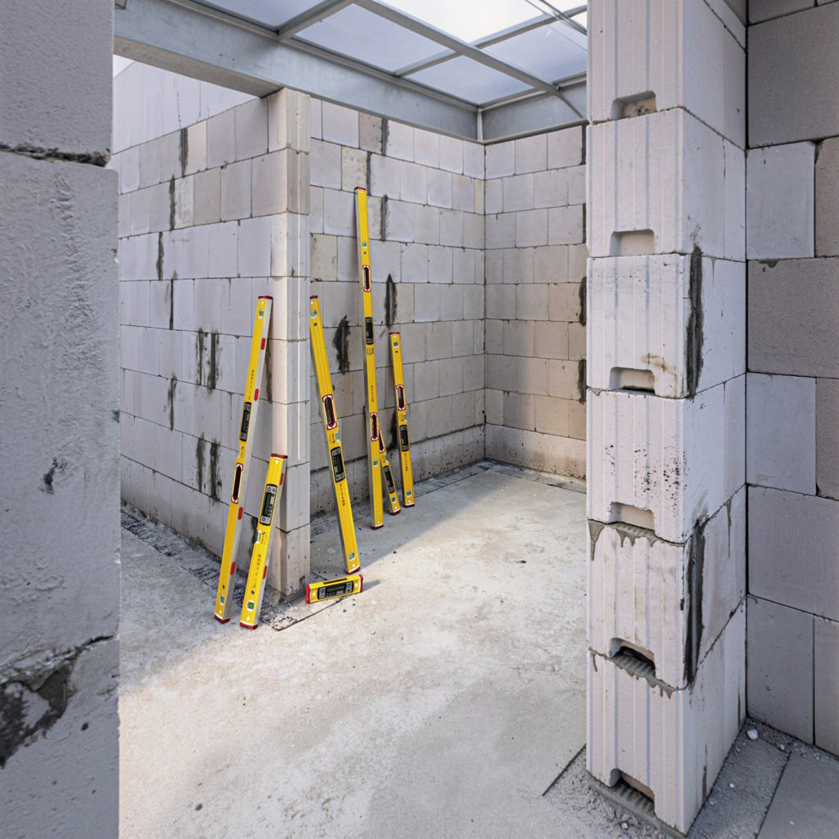 Werkfit Elektronik-Wasserwaage TECH 196 DL in Gelb auf einer Baustelle mit Porenbetonsteinen