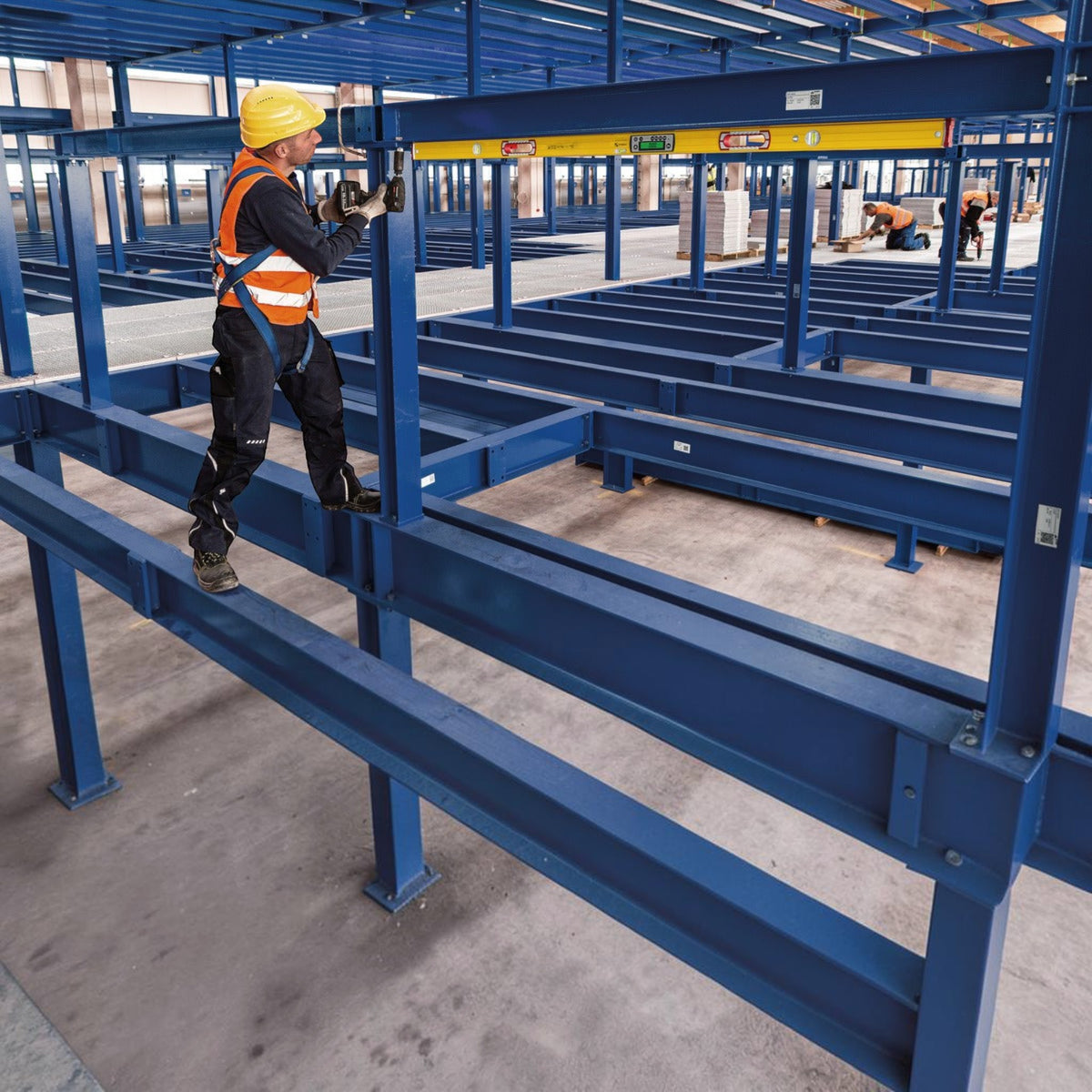 Werkfit Elektronik-Wasserwaage TECH 196M im Einsatz bei der Montage von blauen Stahlträgern auf einer Baustelle
